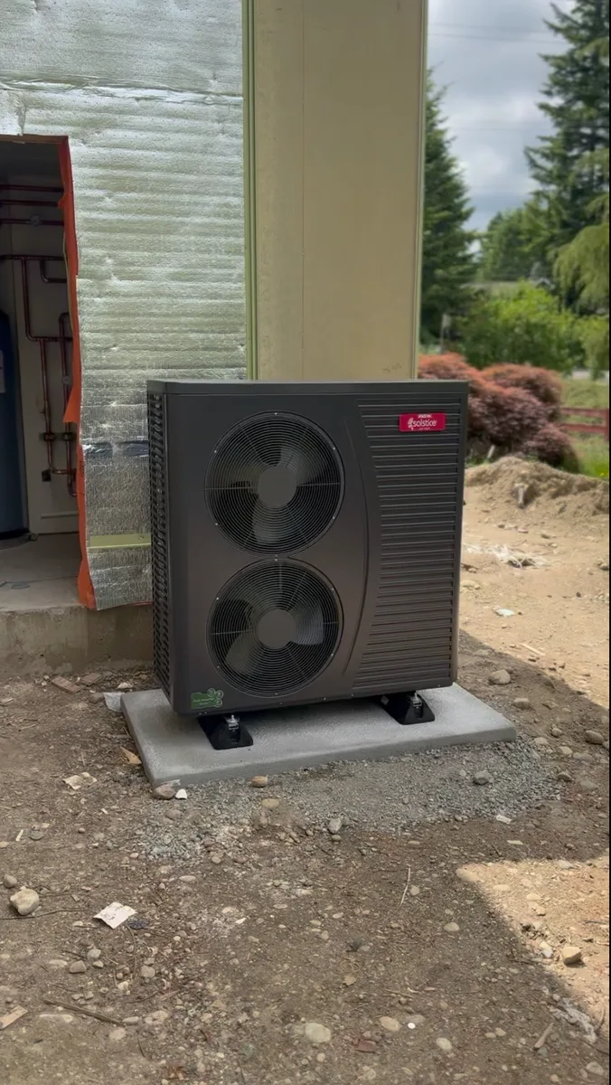 SpacePak Solstice outdoor heat pump set on a poured pad at a house under construction.